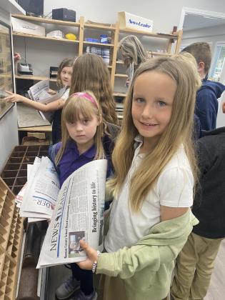 FBCA third grade student Lucy Bird looks over a copy of the News-Leader on a field trip to the newspaper office. Photo by Tracy McCormick-Dishman/News-Leader