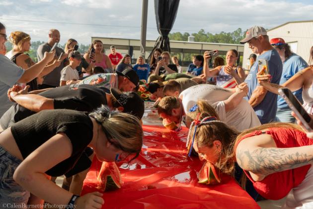 Participants in the watermelon eating contest eat watermelon without using their hands. Photo courtesy of Calen Burnette/Calen Burnette Photography