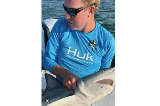 Benny Hendrix holding a shark similar to the shark that recently bit him during a fishing excursion on his boat, the Heavy Hitter. Submitted