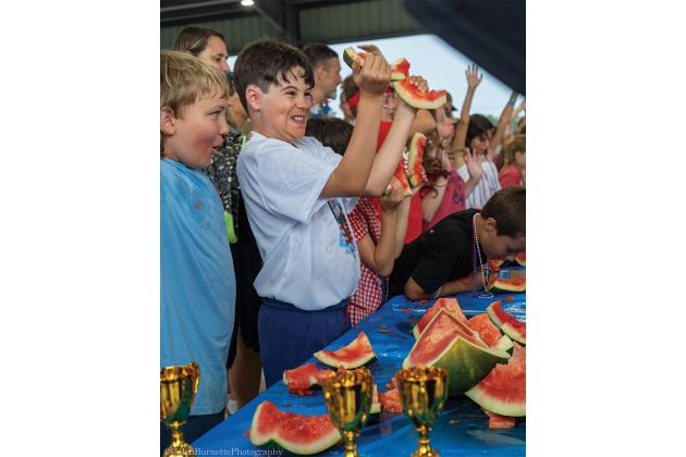 Participants in the kids category, from left, Clyde Head and Frank Camacho react during the watermelon-eating contest. There were around 50 participants in the kids category of the contest. Photo courtesy of Calen Burnette/Calen Burnette Photography