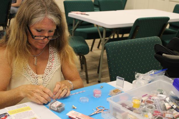 Laurie Valentyne is a longtime volunteer with Front Porch Beads who introduced the group to “tila” beads from Japan. The flat beads with double holes are ideal for crafting rings and bracelets that lay flat against the wearer’s skin.  Photo by Pamela Bushnell/News-Leader