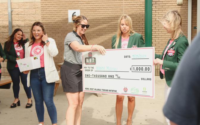 Ashley Murray, middle left, is surprised with a check from TaxSlayer Gator Bowl on Wednesday at Yulee High School where Murray teaches. The check, presented by Jennifer Estes, middle right, and Christie Hill, right, is a part of the Most Valuable Teacher Initiative. The check is worth $1,000 to use in her classroom. Also pictured, Kayla Vanderlaan, left, Director of Marketing and Community Relations for Gator Bowl. Photo by Ashley Chandler/News-Leader