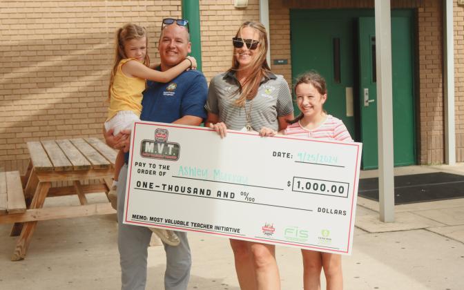 From Left: Hannah, George, Ashley and Maddie Murray pose with a check from TaxSlayer Gator Bowl that Ashley received as a part of the Gator Bowl's Most Valuable Teacher Initiative. Photo by Ashley Chandler/News-Leader