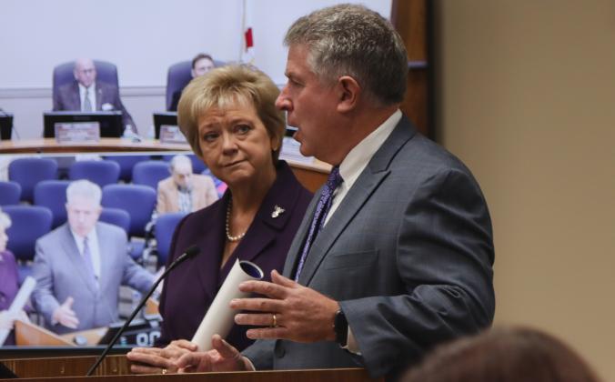 Doug Adkins, right, talks Oct. 16 at the Nassau County Board of County Commissioners meeting after the board proclaimed October 2024 as Emily Adkins Blood Clot Awareness Month. Janet Adkins, Supervisor of Elections, right, listens. Photo by Ashley Chandler/News-Leader