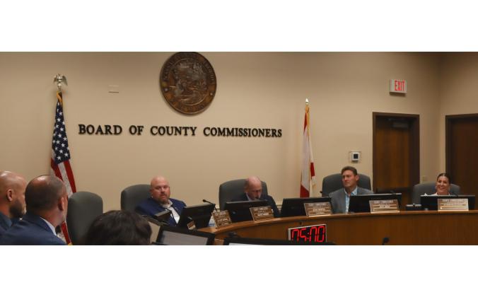 From left, commissioners Klynt Farmer, John Martin, Jeff Gray and Alyson McCullough listen as Assistant County Manager Marshall Eyerman, far left, talks Monday at the Board of County Commissioners meeting. Eyerman said a grant the county accepted Monday will cover most of the cost of a 48–foot Coastal Fast Response Boat Fire Rescue vessel. Photo by Ashley Chandler/News-Leader