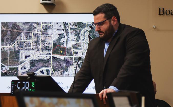 Joshua Macbeth, senior planner/designer in the Nassau County Planning Department presents during a Quasi-Judicial Public Hearing on Monday at the Nassau County Board of County Commissioners meeting. The Final Development Plan approved at the hearing was for Nassau Crossing, Planned Unit Development, Parcel B, pictured behind Macbeth. Photo by Ashley Chandler/News-Leader