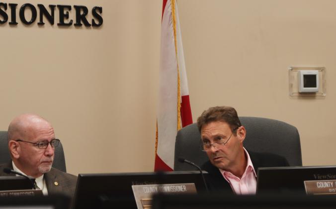 Commissioner Jeff Gray, right, talks Wednesday at the Board of County Commissioners' regular session. John Martin, left, listens. Photo by Ashley Chandler/News-Leader