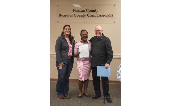 Nassau County Commissioner Alyson McCullough, from left, poses with Breast Cancer Survivors Shanita Burks and Jose Garcia on Oct. 16 at the Board of County Commissioners meeting. Photo by Ashley Chandler/News-Leader