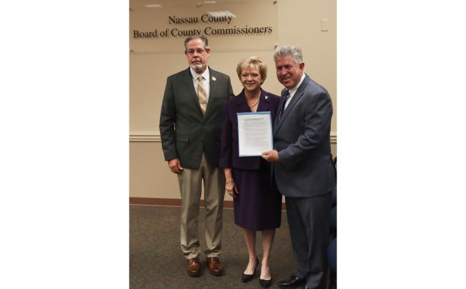 From left Commissioner A.M. "Hupp" Huppmann, Janet Adkins, Doug Adkins, pose for a photo with the proclamation declaring the month of October 2024 as Emily Adkins Blood Clot Awareness Month. Photo by Ashley Chandler/News-Leader