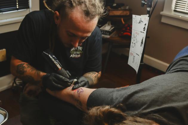 Sailor Dave tattoos a flash-tattoo fox design on Sunday at The Salty Fox Tattoo &amp; Apothecary. Photo by Ashley Chandler/News-Leader