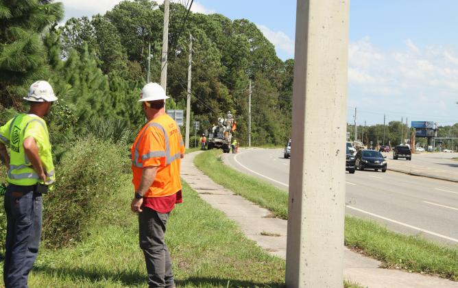 Electricians work on power lines midday Friday at State Road 200 and Pages Dairy Road in Yulee following Hurricane Helene. Several electrical companies were contracted to assist in getting power up and running through the state. Photo by Ashley Chandler/News-Leader