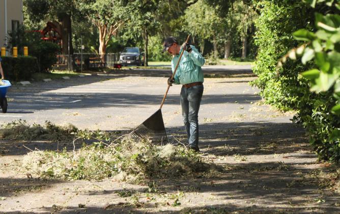 Gannon Woods, a member of Amelia Baptist Church, helps to clean up the church's parking lot Friday. Woods and others volunteered to clean up debris on the church's property after Hurricane Helene spread Tropical Storm force winds into Nassau County in the early hours of Friday morning. Photo by Ashley Chandler/News-Leader