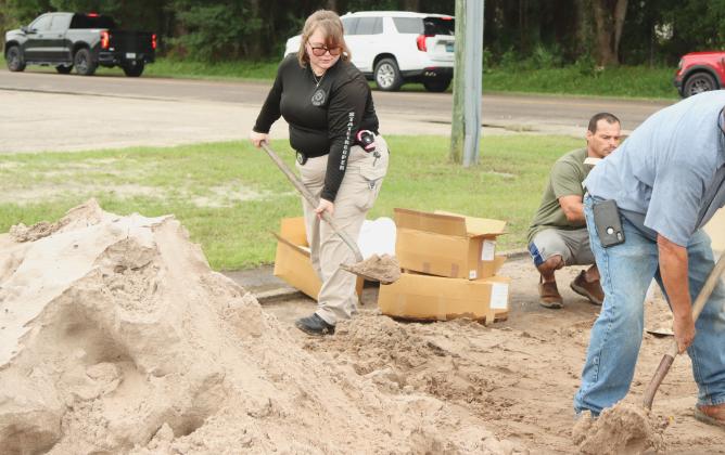 Emily Marell, state trooper, fill bags of sand Monday at the Yulee Ballpark in preparation for Hurricane Milton. Photo by Ashley Chandler/News-Leader