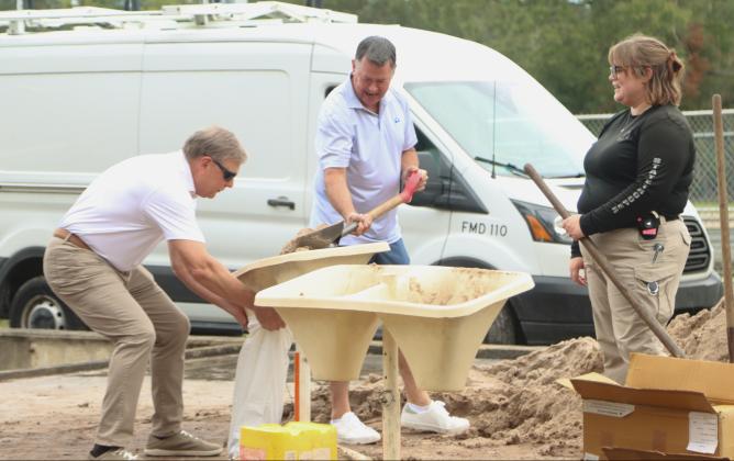 From left: Jeff Householder, Ray Martin and Emily Marell, state trooper, fill bags of sand Monday at the Yulee Ballpark in preparation for Hurricane Milton. Photo by Ashley Chandler/News-Leader