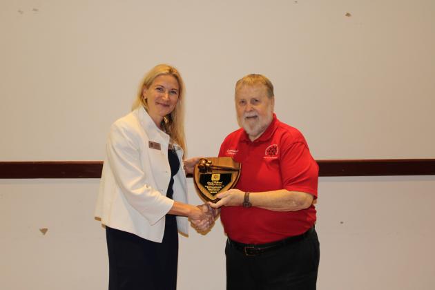 Miriam Hill presented a plaque to Danny Fullwood from the Ocean Highway and Port Authority, thanking him for his long tenure on the port authority’s commission. Photo by Julia Roberts/News-Leader