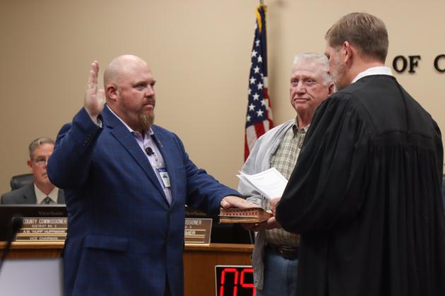 Commissioner Klynt Farmer is sworn in for another term. From left, Farmer, his father Kenny Farmer and Judge Steve Fahlgren. Photo by Ashley Chandler/News-Leader