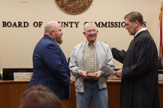 Commissioner Klynt Farmer is sworn in for another term. From left, Farmer, his father Kenny Farmer and Judge Steve Fahlgren. Photo by Ashley Chandler/News-Leader