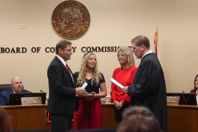 Commissioner Jeff Gray is sworn in for another term. From left, Gray, his daughter Brook, his wife Diana and Judge Steve Fahlgren. Photo by Ashley Chandler/News-Leader