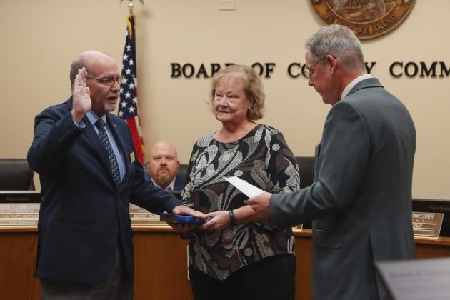 Commissioner John Martin is sworn in for another term. From left, Martin, his wife Donna and Commissioner A.M. “Hupp” Huppmann. Photo by Ashley Chandler/News-Leader