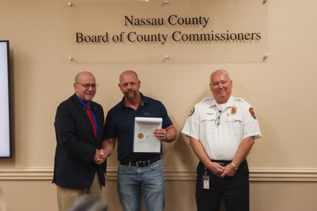 John Martin, Peter Gunnel, and Chief Greg Roland pose for a photo Dec. 18 with a plaque recognizing Gunnel's retirement after 31 years with Fire Rescue. Photo by Ashley Chandler/News-Leader
