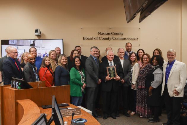 John A. Crawford poses with staff Dec. 18 at the Board of County Commissioners meeting after the board recognized his his retirement and 28 years of service as Nassau County Clerk of Courts and Comptroller. Photo by Ashley Chandler/News-Leader