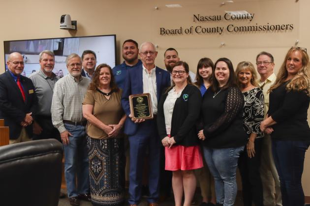 Michael Hickox,  retiring as Nassau County Property Appraiser after 12 years of service, poses with staff and a proclamation recognizing his retirement and years of service on Dec. 18 at the Board of County Commissioners meeting, recognizing his retirement after 12 years of service as Nassau County Property Appraiser after 12 years of service. Photo by Ashley Chandler/News-Leader