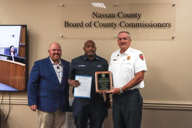 Commissioner Klynt Farmer, Dale Green and Chief Brady Rigdon pose for a photos after Board of County Commissioners recognized Green's retirement in October. Photo by Ashley Chandler/News-Leader