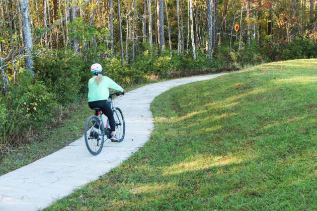 A biker utilizes one of the newly built trails at Nassau Crossing Park. The long-awaited  Westside Regional Park will begin construction early next year on Phase One which consists of an amphitheater, airnasium, a large playground, walking trails, a dog park and more. Photo by Ashley Chandler/News-Leader