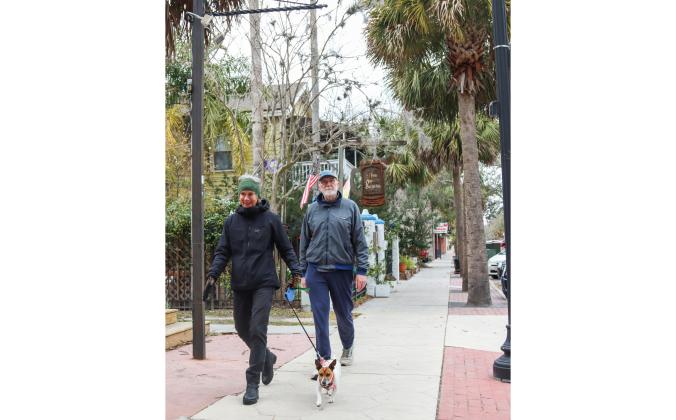 Ellen Foltz and Dave Capps bundled up to take a morning walk with Arlo on Tuesday morning in Downtown Fernandina Beach. Temperatures were expected to drop overnight bringing chances of icy road conditions and snow into this morning. Photo by Ashley Chandler/News-Leader