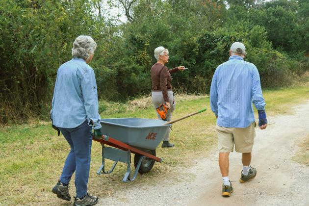 Kathy Russell, conservation and environmental manager for city of Fernandina Beach, leads volunteers during an Invader Raiders cleanup event in December on city conservation land. The group was working to clear trash, debris and invasive plant species from the property. Photo by Ashley Chandler/News-Leader
