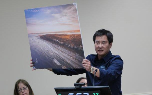 In April 2023, Peter Brual showed the Nassau County Board of County Commissioners and the audience a picture of the south end of Amelia Island, asking the BOCC to vote against a settlement that would allow 85-foot condominiums to be built. “This is a picture of the crown jewel of the whole area,” Brual said. “It’s why we’re here. Think about, if Riverstone wins, what this might look like. Can you see it? Towers over canopy treetops.” File photo/News-Leader