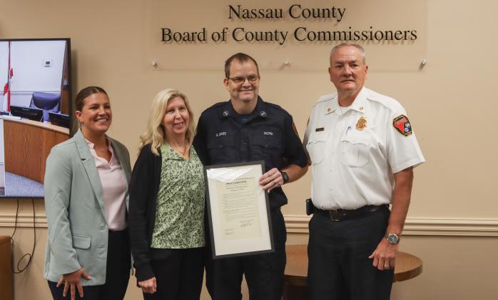 Gregory Jones, middle, was recognized for his retirement from Nassau County Fire Rescue at the Feb. 19 Board of County Commissioners meeting. From left, Commissioner Alyson McCullough, Jones's wife Janet, Jones and Fire Chief Brady Rigdon. Photo by Ashley Chandler/News-Leader