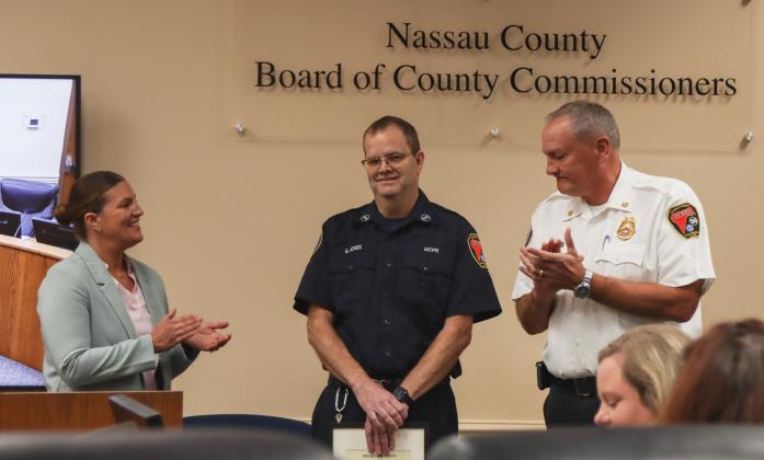 Gregory Jones, middle, was recognized for his retirement from Nassau County Fire Rescue at the Feb. 19 Board of County Commissioners meeting. From left, Commissioner Alyson McCullough, Jones and Fire Chief Brady Rigdon. Photo by Ashley Chandler/News-Leader