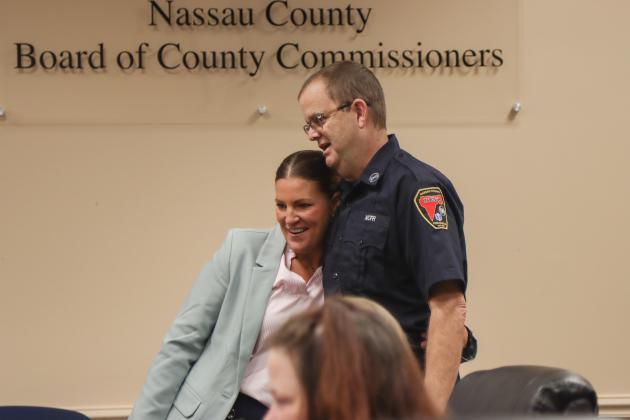 Commissioner Alyson McCullough, left, presents a proclamation to Gregory Jones recognizing his retirement from Nassau County Fire Rescue at the Feb. 19 Board of County Commissioners meeting. Photo by Ashley Chandler/News-Leader