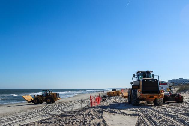 Workers clean dredging equipment Monday at Main Beach. Photo by Ashley Chandler/News-Leader