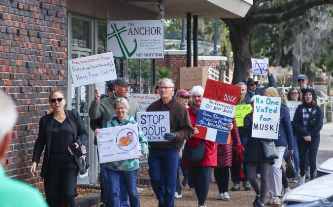 Protesters were Downtown on Thursday to voice their opinion on Social Security, DOGE and Elon Musk to Congressman Aaron Bean and his staff. On left, is Nassau County Democratic Party Chair Suzanne Sapp. Photo by Ashley Chandler/News-Leader