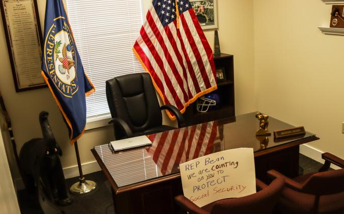A protester left a sign at Congressman Aaron Bean's desk at his Fernandina Beach office calling on him to "protect Social Security." Protesters were Downtown on Thursday to voice their opinion on DOGE, Social Security and Elon Musk to Congressman Aaron Bean and his staff. Photo by Ashley Chandler/News-Leader