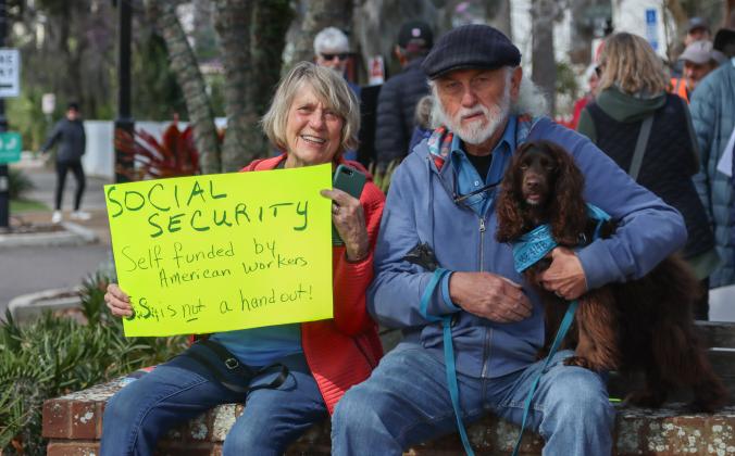 Doc and Suzi Hearn attend a rally Thursday in Downtown Fernandina Beach with their dog, Dove. Protesters rallied outside Congressman Aaron Bean's Fernandina Beach office to voice their opinion on DOGE, Social Security and Elon Musk to Congressman Aaron Bean and his staff. Photos by Ashley Chandler/News-Leader
