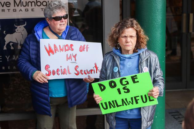 From left, Rhette Angus and Kathy Allen hold signs at a rally on Thursday in Downtown Fernandina Beach. Protesters chanted and donned signs expressing concern over social security, DOGE and Elon Musk outside Congressman Aaron Bean's Downtown Fernandina Beach office. Photo by Ashley Chandler/News-Leader