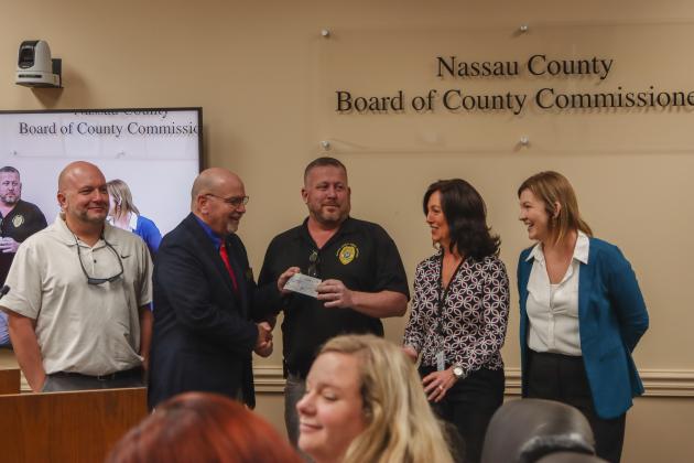 Commissioner John Martin presents the first donation to Imagine Nassau in December at a Board of County Commissioners meeting. The nonprofit founded by Nassau County will raise funds and apply for grants for projects within Parks &amp; Recreation, Fire Rescue, Animal Services and Conservation and Land Acquisition Management. From left, Jay Robertson, treasurer; Martin, Tim Maguire, vice-president; Holly Coyle, secretary; and Brandy Carvalho, acting executive director. Photo by Ashley Chandler/News-Leader