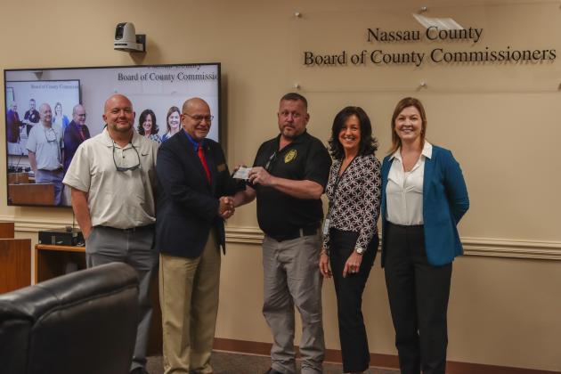 Commissioner John Martin presents the first donation to Imagine Nassau in December at a Board of County Commissioners meeting. The nonprofit founded by Nassau County will raise funds and apply for grants for projects within Parks &amp; Recreation, Fire Rescue, Animal Services and Conservation and Land Acquisition Management. From left, Jay Robertson, treasurer; Martin, Tim Maguire, vice-president; Holly Coyle, secretary; and Brandy Carvalho, acting executive director. Photo by Ashley Chandler/News-Leader