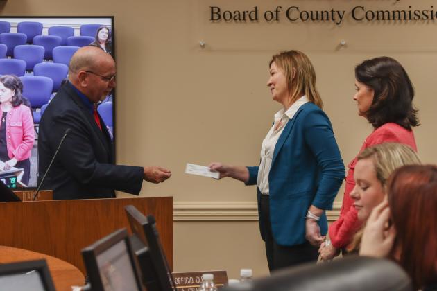 Commissioner John Martin presented the first donation to Imagine Nassau in December at a Board of County Commissioners meeting. From left, Martin, Brandy Carvalho, acting executive director for Imagine Nassau (Nassau County director of strategic advancement); and Assistant County Attorney Abigail Jorandby. Photo by Ashley Chandler/News-Leader