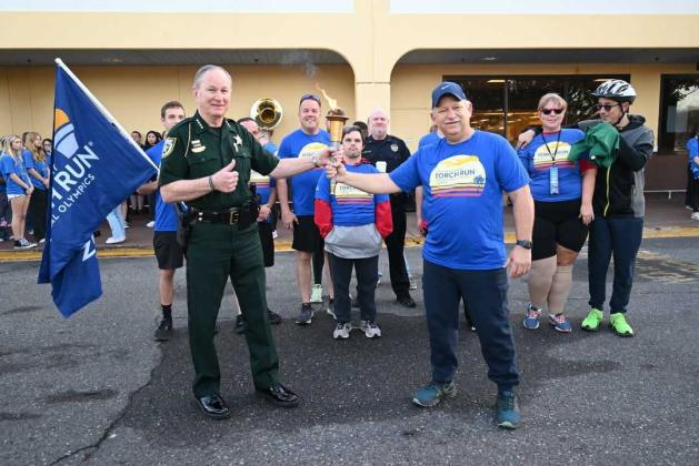 Captain David Bishop, right, passes the torch to Sheriff Bill Leeper on Thursday after the Fernandina Beach Police Department completed its' Law Enforcement Torch Run. The Nassau County Sheriff's Office held it's torch run Friday in Callahan. Proceeds from the events benefit Special Olympics. Submitted photo