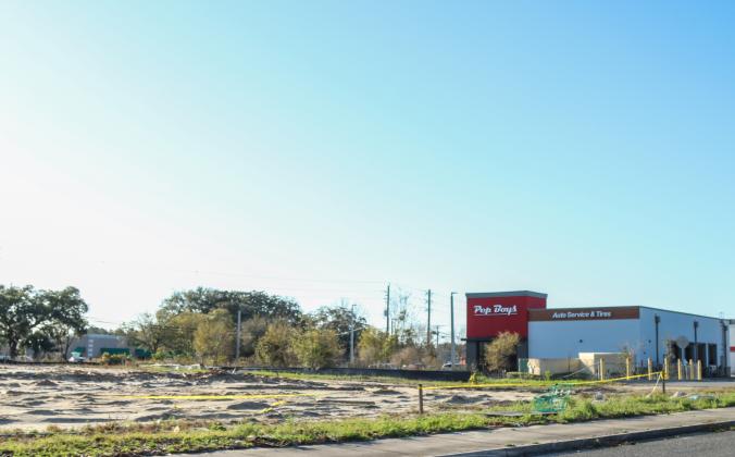 Pep Boys Auto Service and Tires, pictured March 11, no longer neighbors a boarded up building, but an empty dirt lot after the building once meant to be a Hwy 55 Burgers, Shakes &amp; Fries, was torn down last week. Photo by Ashley Chandler News-Leader