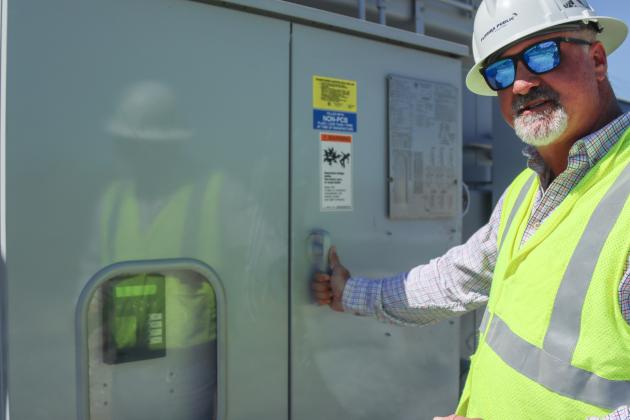 Brandon Jordan, substation technician with Florida Public Utilities, describes the mechanisms of the new transformer.