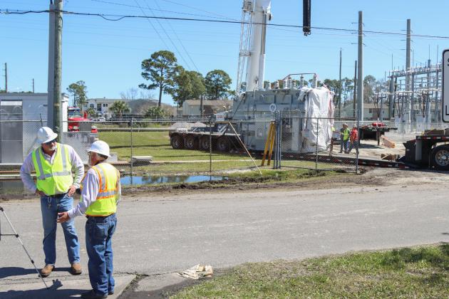 Brandon Jordan, substation technician with FPU, left, and Bill Edwards of Engineered Powered Products, work with other technicians and contractors to move a new transformer into the substation located at Lime and 10th streets.