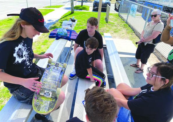 Pinson, the area’s first Game Changers, talks skateboarding with the Littles, right, on March 1 at Main Beach. Photo by Beth Jones/News-Leader