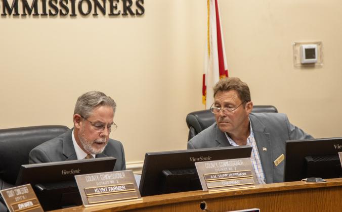 Chairman A.M. "Hupp" Huppmann, left, reads the resolution approved Monday that states the board's unanimous position against House Bill 1221. Commissioner Jeff Gray reads along. Photo by Ashley Chandler/New-Leader
