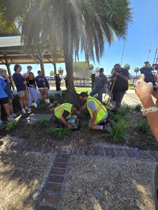 City employees Steven Flannery and David Taylor place a time capsule in the ground that will not see the light of day until 2075. Photo by Julia Roberts/News-Leader