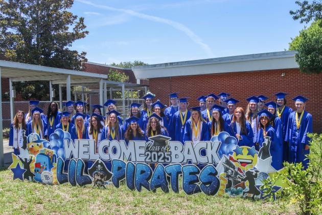 Fernandina Beach High School graduates who attended Southside Elementary pose for a group photos outside the school Thursday. Photo by Ashley Chandler/News-Leader